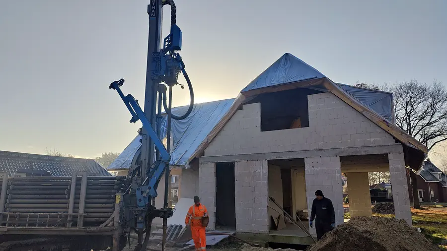 Boorstelling voor een nieuwbouwwoning tijdens het aanleggen van een bodemlus, in het ochtendlicht