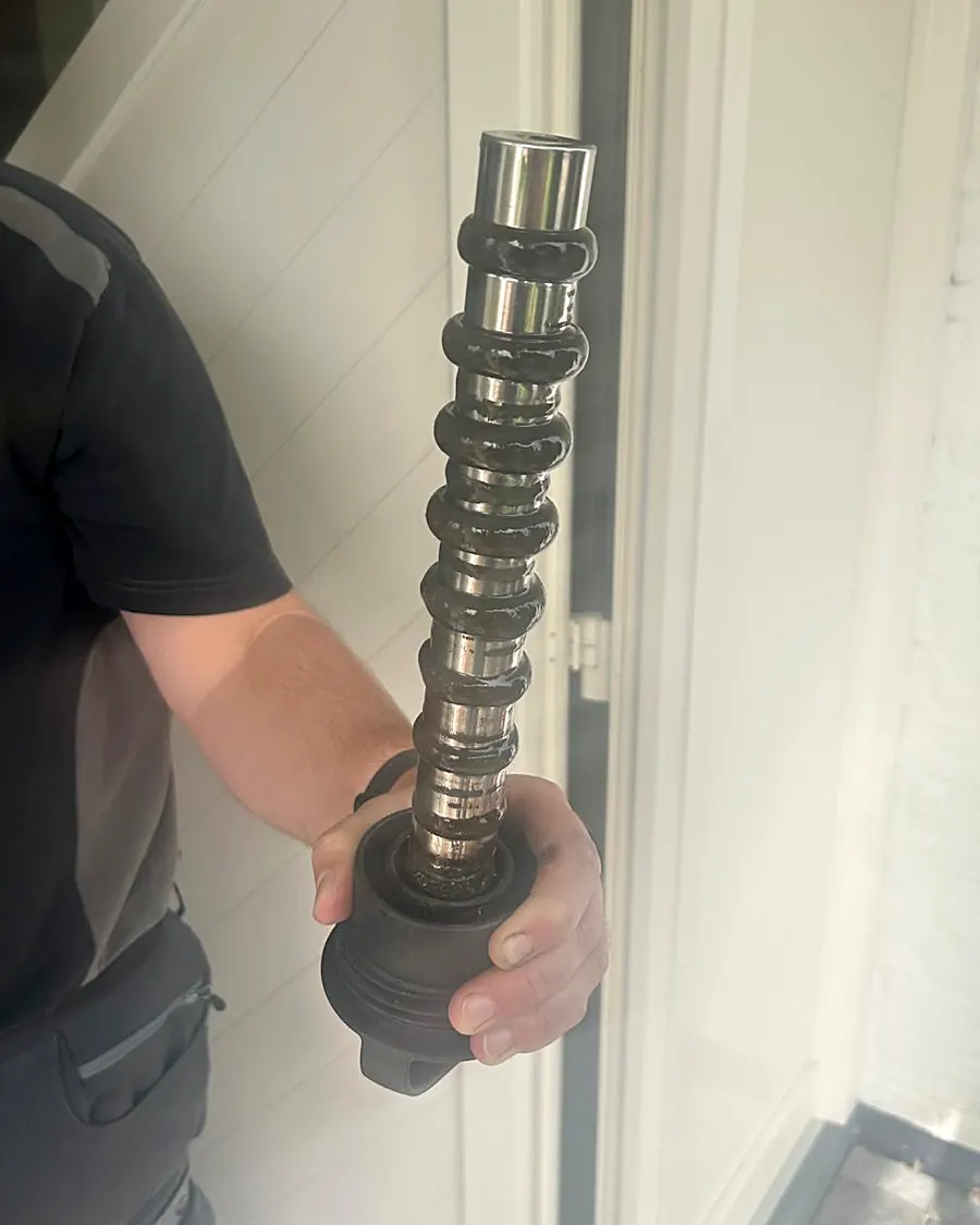 Magneetstaaf met dikke ringen zwart magnetiet, afgevangen tijdens het spoelen van een cv-installatie