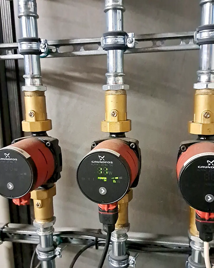 Drie circulatiepompen met manometers in RVS-leidingwerk, één met verlicht display