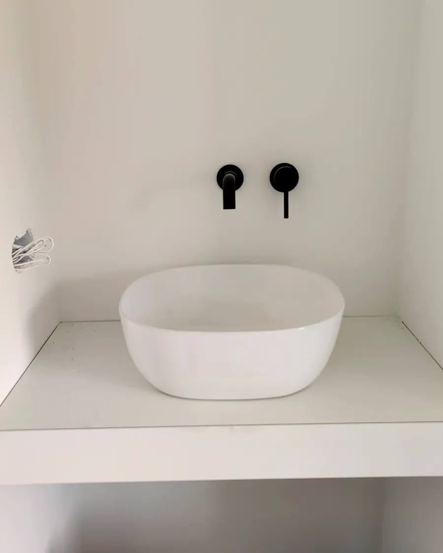 Wastafel met inbouwkranen op een strak blad in een nieuwe badkamer
