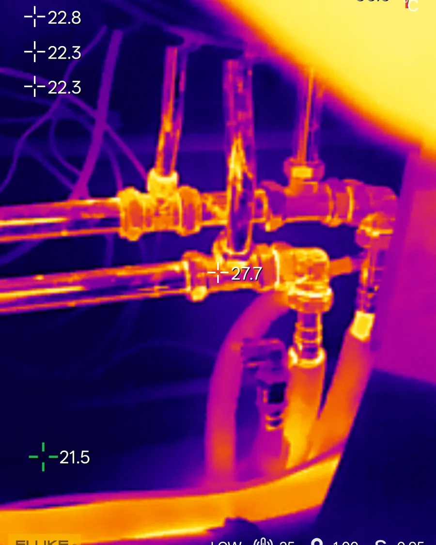 Warmtebeeld van cv-leidingwerk met temperatuurmetingen: de aanvoer licht op, de omgeving blijft koel