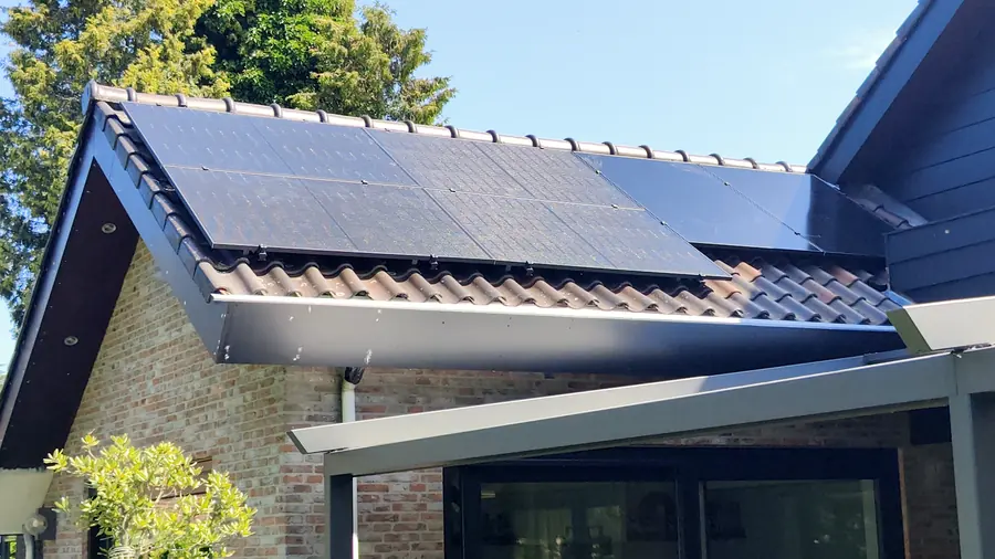 Zonnepanelen op het schuine dak van een woning met veranda